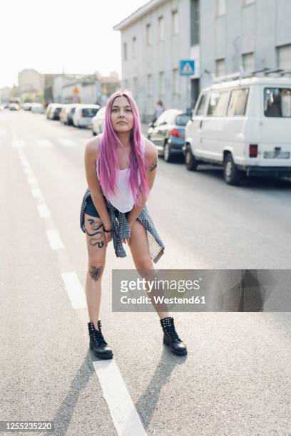 portrait of a stylish young woman with pink hair standing on the street in the city - short hair photos et images de collection