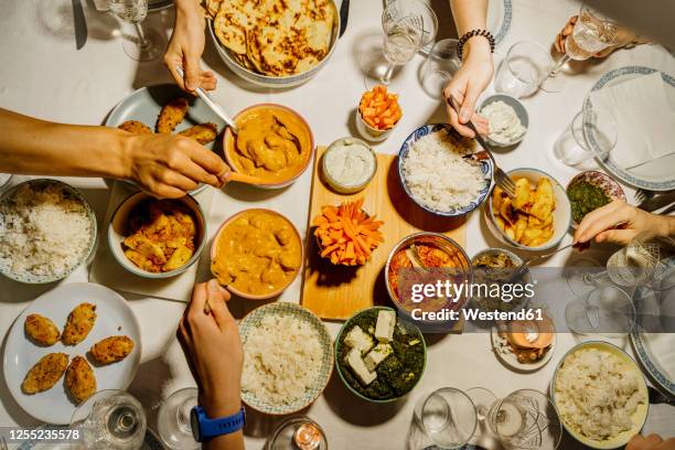 hands of people dining together around table set with indian food - indian food - fotografias e filmes do acervo