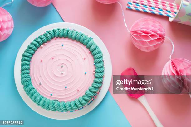 studio shot of pink birthday cake and paper party decorations - cake party bildbanksfoton och bilder