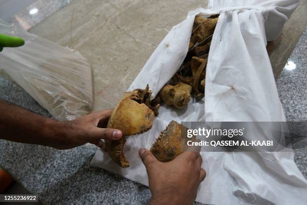 The remains of inmates of the Badush prison, killed in Mosul by Islamic State group jihadists in 2014 and found in mass graves in 2017, are checked...