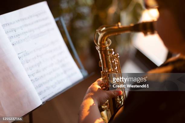 crop view of boy exercising to play the saxophone at home - saxofoon stockfoto's en -beelden