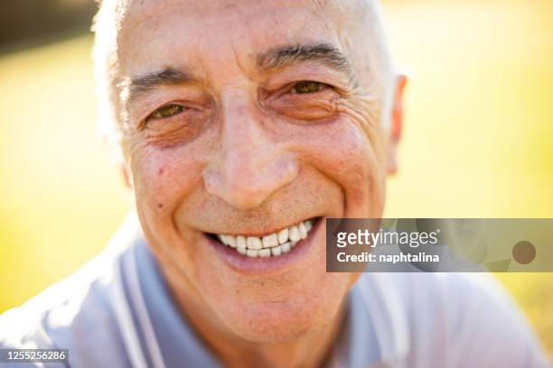 smiling happy senior man in natural defocused background - grandfather face stock pictures, royalty-free photos & images