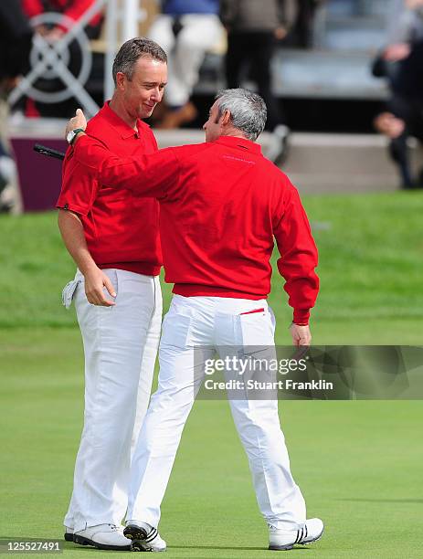 Mark Foster is congratulated by Paul McGinley, captain of the Great Britain and Ireland team as his match secured victory for the team during the...