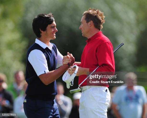 Matteo Manassaro of the Continental Europe team congratulates Ian Poulter of the Great Britain and Ireland team on winning their match on the 18th...