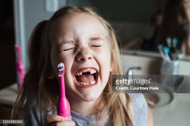 linda chica de dientes de nalgas se ríe después de cepillarse los dientes en casa en el baño - hueco entre dientes fotografías e imágenes de stock
