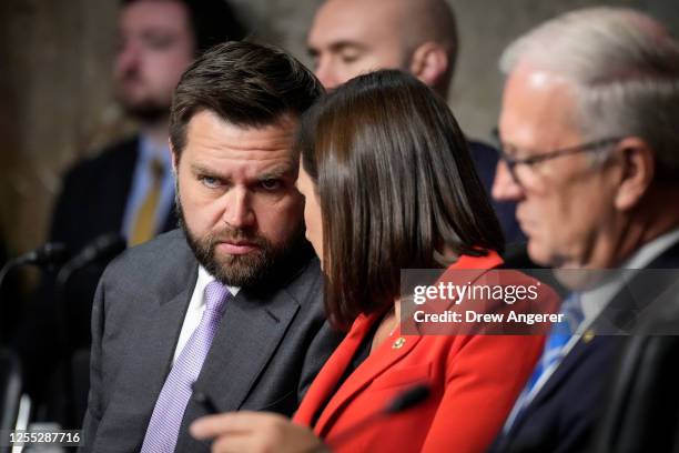 Sen. J.D. Vance talks with Sen. Katie Britt during a Senate Banking Committee hearing on Capitol Hill May 16, 2023 in Washington, DC. The hearing was...