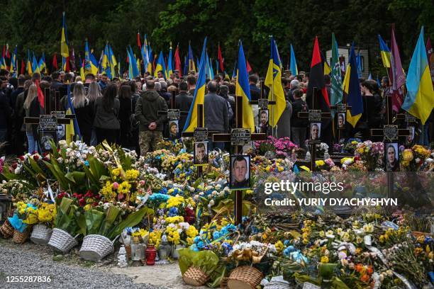 People attend the funeral of Ukrainian serviceman Volodymyr Nestor, killed in combat with Russian troops, at a cemetery in Lviv on May 16 amid the...