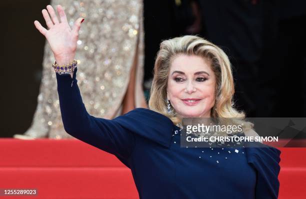 French actress Catherine Deneuve waves as she arrives for the opening ceremony and the screening of the film "Jeanne du Barry" during the 76th...