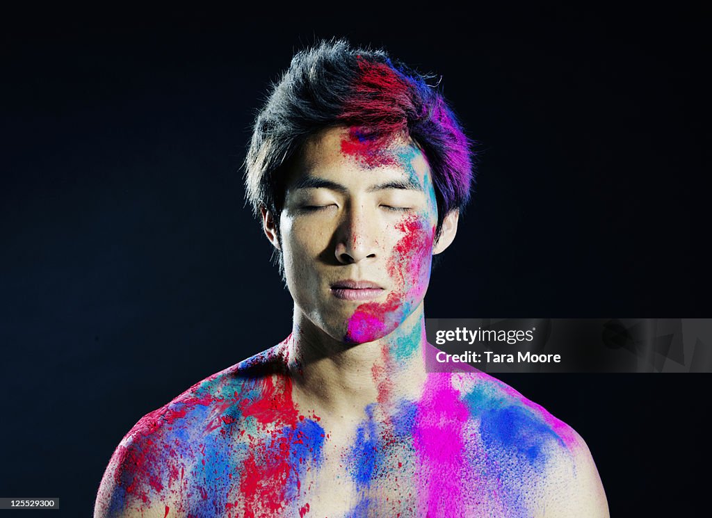Portrait of man covered in colorful powder