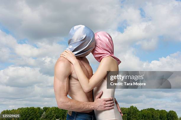 man & woman with faces covered by material kissing - freaky couples 個照片及圖片檔