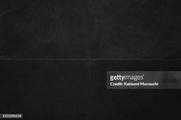 folded black color paper texture background - zwarte kleur stockfoto's en -beelden
