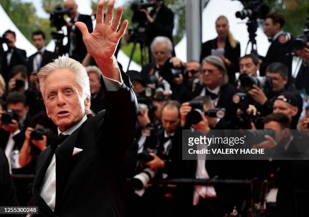 Actor and Honorary Palme d'or of the 76th Festival de Cannes Michael Douglas waves as he arrives for the opening ceremony and the screening of the...