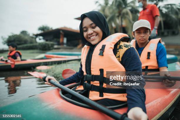asian sibling kayaking at river - life jacket stock pictures, royalty-free photos & images