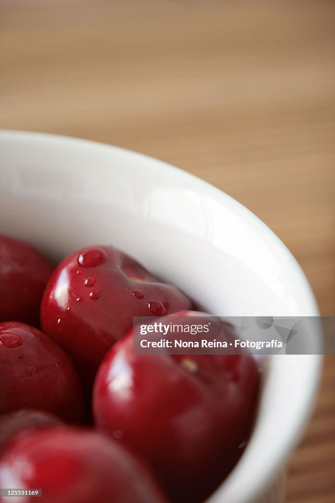 Red cherries in white bowl