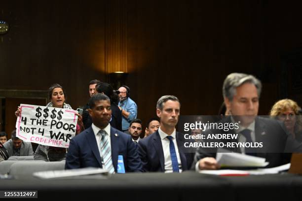 Code Pink demonstrator holds a sign as US Secretary of State Antony Blinken testifies during a Senate Appropriations Committee hearing on the 2024...