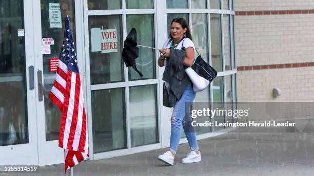 Voters enter under a rainstorm to cast their ballots at Bryan Station High School on May 16 as Kentucky went to the polls on primary election day....