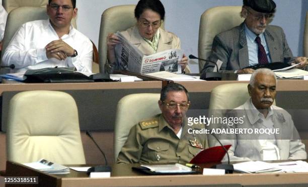 Raul Castro , Minister of the Armed Forces in Cuba, sits by Juan Almeida Bosque as they listen during a parlimentary session, next to an empty chair...