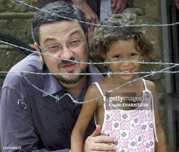 Brazilian Economy Minister Antonio Palocci poses for photographers with a local girl from the "Irma Dulce" neighborhood of Teresina, northern Brazil,...