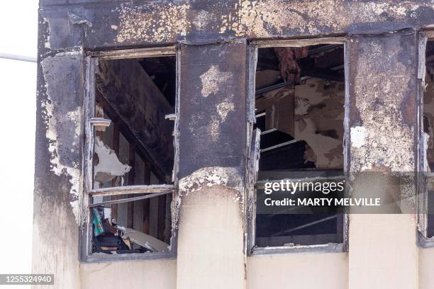 Burnt out window is seen at the Loafers Lodge hostel in the aftermath of a fire in the suburb of Newtown in Wellington on May 17, 2023. A fire ripped...