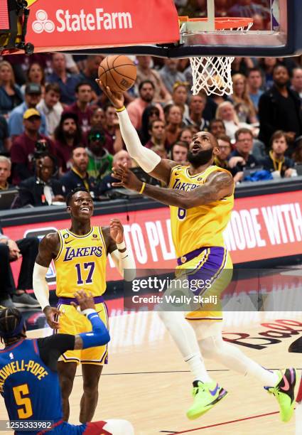 Los Angeles Lakers forward LeBron James goes up for a basket as Denver Nuggets guard Kentavious Caldwell-Pope attempts to draw a charge during the...