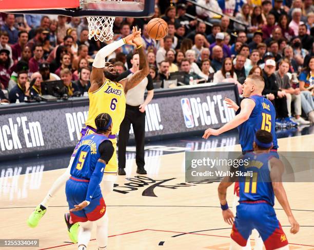 Los Angeles Lakers forward LeBron James, top left, loses the ball while going up to the basket as Denver Nuggets guard Kentavious Caldwell-Pope...