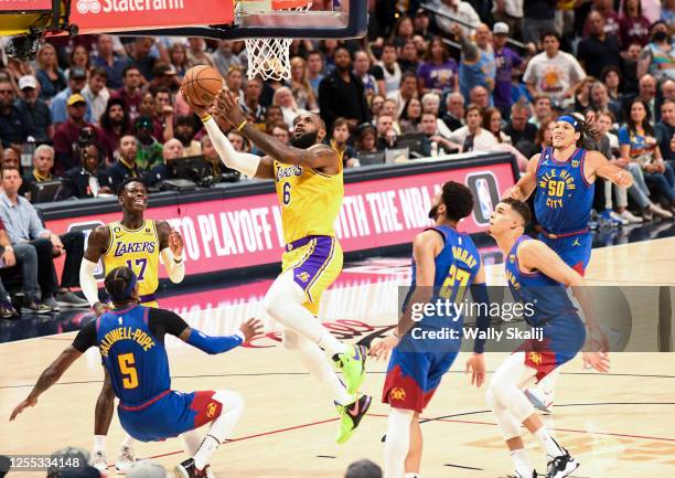 Los Angeles Lakers forward LeBron James goes up for a basket as Denver Nuggets guard Kentavious Caldwell-Pope attempts to draw a charge during the...