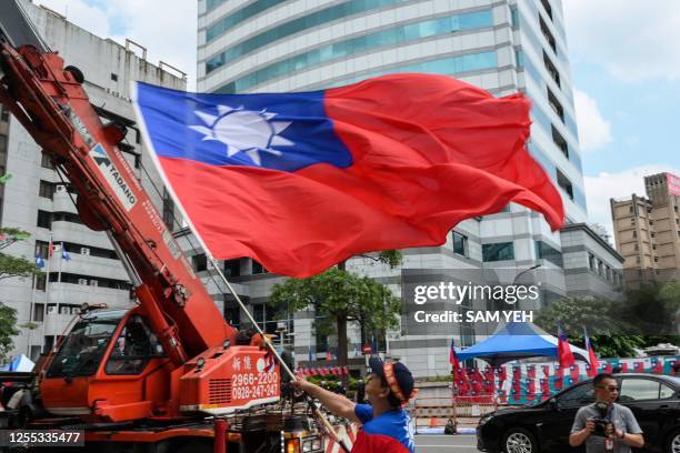 Supporter of the main opposition Kuomintang waves a Taiwanese flag during a rally outside the KMT headquarters ahead of the party's expected...