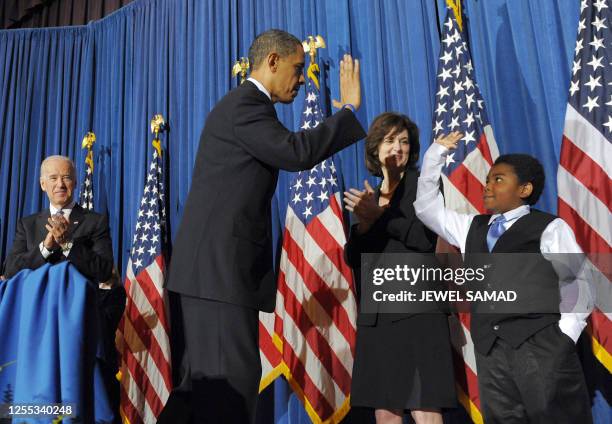 President Barack Obama gives a "high five" to 11 year-old Marcelas Owens after holding a rally celebrating the passage and signing into law of the...