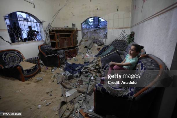 Child sits on a sofa in their wrecked house as Palestinians inspect the site aftermath of Israeli attacks as residents return their burnt houses...
