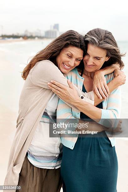 women hugging on beach - female friendship stock pictures, royalty-free photos & images
