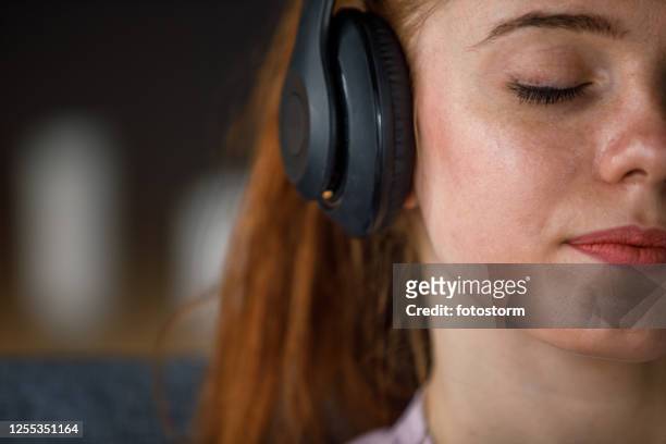 ritaglia lo scatto di una giovane donna che si diverte ad ascoltare musica con gli occhi chiusi - audiobook foto e immagini stock