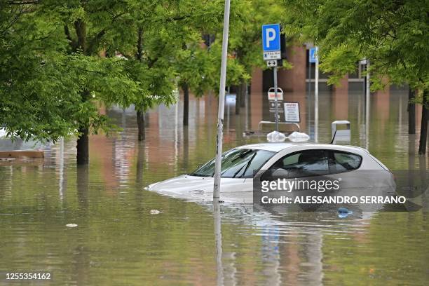 Picture taken in Cesena on May 17, 2023 shows a car in a flooded supermarket area after heavy rains have caused major floodings in central Italy,...