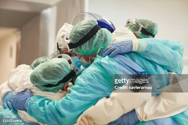 artsen en verpleegkundigen met armen rond elkaar in ondersteuning - person in emergency hospital stockfoto's en -beelden