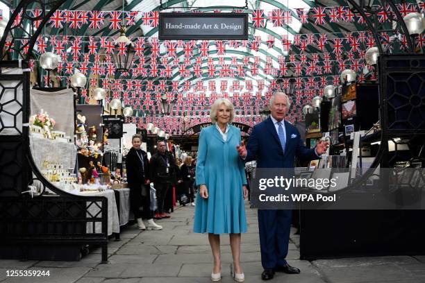 King Charles III and Queen Camilla look at stands at Covent Garden market on May 17, 2023 in London, England.