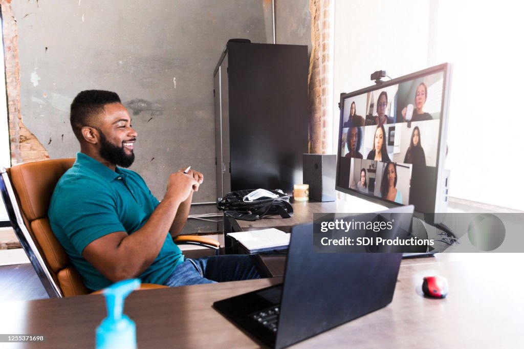 Cheerful businessman video chats with colleagues