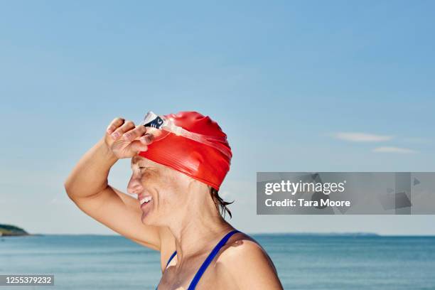 mature woman in swimwear by sea - swimming cap stock pictures, royalty-free photos & images