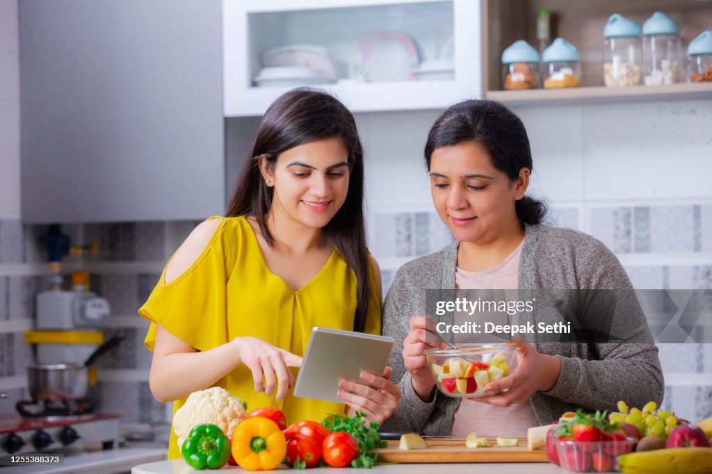 Two Young woman at kitchen - stock photo