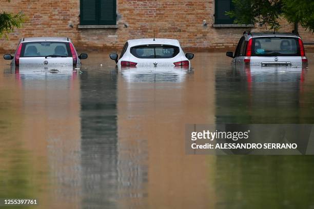 Flooded cars are pictured in a street of Cesena on May 17, 2023 after heavy rains caused major floodings in central Italy. Trains were stopped and...