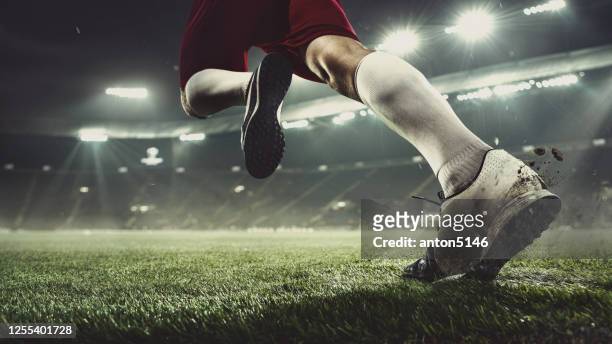 close up football or soccer player at stadium in flashlights - motion, action, activity concept - taking a shot sport stock pictures, royalty-free photos & images