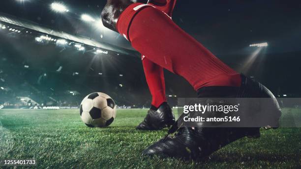 närbild fotboll eller fotbollsspelare på stadion i ficklampor - rörelse, action, aktivitet koncept - sparka bildbanksfoton och bilder