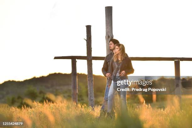 artistic portrait of young couple in love watching at horisont on sunset - horisont stock pictures, royalty-free photos & images