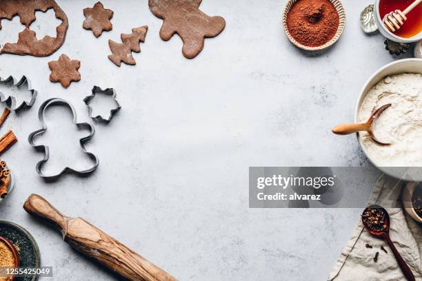 biscuits de noël d’homme de pain d’épice de cuisson dans la cuisine - flour christmas photos et images de collection