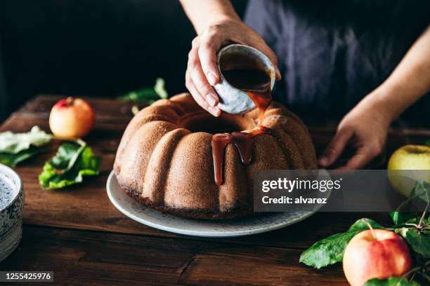 mulher preparando delicioso bolo de maçã bundt - cinnamon - fotografias e filmes do acervo