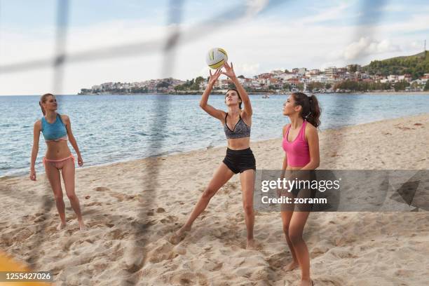 young women in bikinis playing recreational beach volley - setter stock pictures, royalty-free photos & images