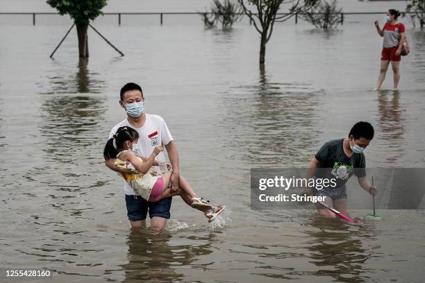 Residents play in flooded Jiangtan park caused by heavy rains along the Yangtze river on July 10, 2020 in Wuhan, China. Wuhan on 5th July upgraded...