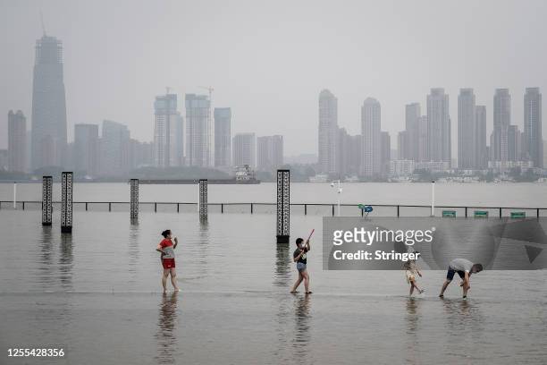 Residents play in flooded Jiangtan park caused by heavy rains along the Yangtze river on July 10, 2020 in Wuhan, China. Wuhan on 5th July upgraded...