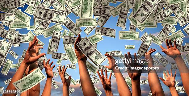 hands reaching to falling money - disney dollars stock pictures, royalty-free photos & images