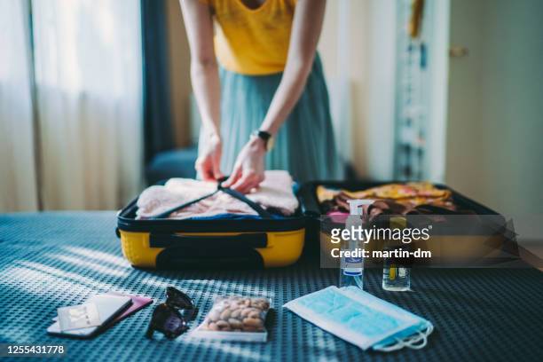 suitcase packing for travel, covid-19 - pandemic illness imagens e fotografias de stock