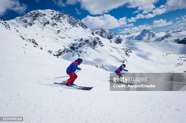 couple skiing in the mountains - blackcomb mountain stock pictures, royalty-free photos & images