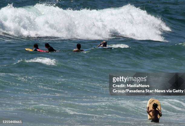 Surfers wait for a wave in Hermosa Beach on Wednesday, July 8, 2020.